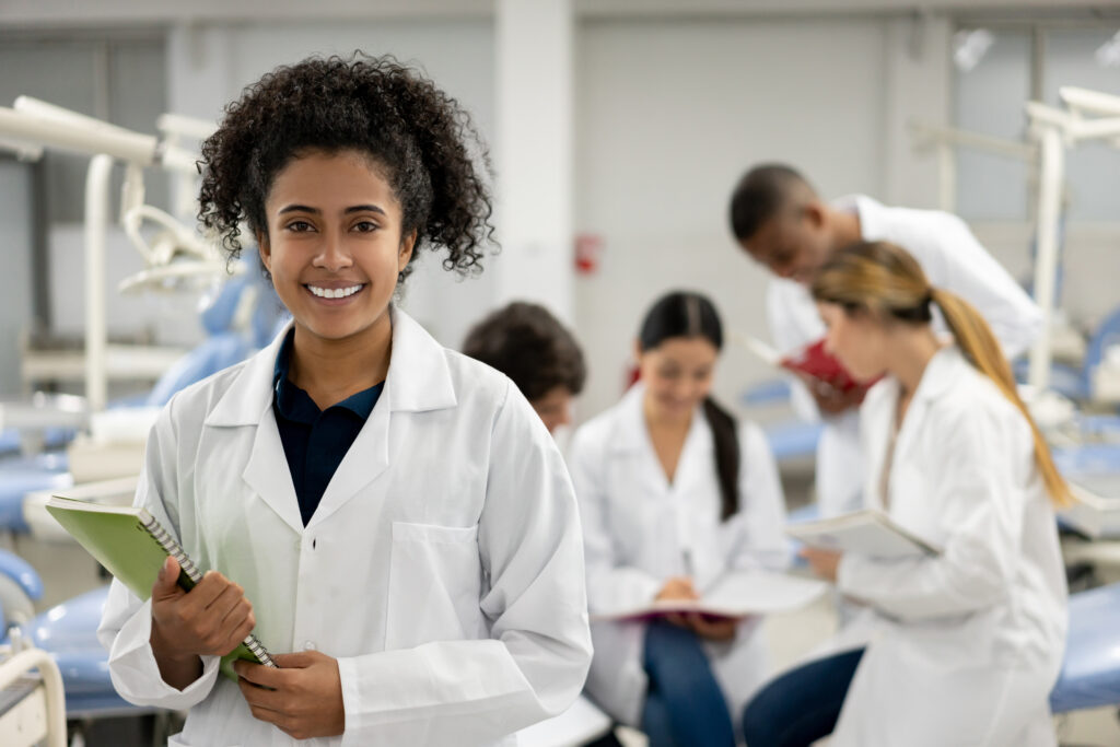 medical student holding notebook smiling and looking at camera